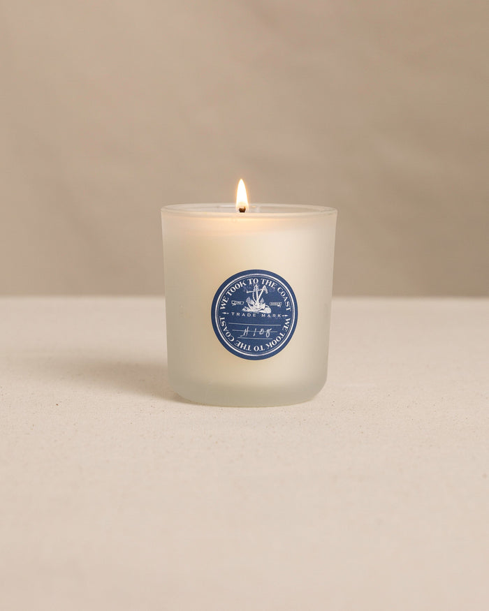 The front view of the We Took to the Woods And We Danced in the Sea Candle at Southern Tide - White