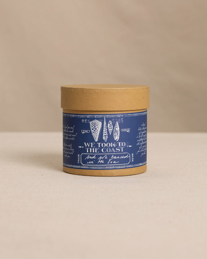 The front view of the We Took to the Woods And We Danced in the Sea Candle at Southern Tide - White