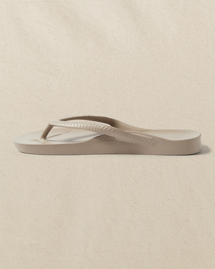 The left side view of the Southern Tide Archie's Taupe Arch Support Flip Flop by Southern Tide - Taupe