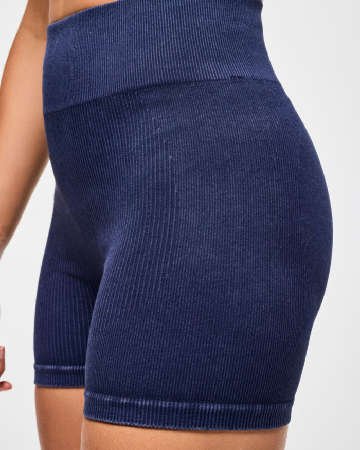 Close view of denim corduroy blue biker shorts shot on a white background.