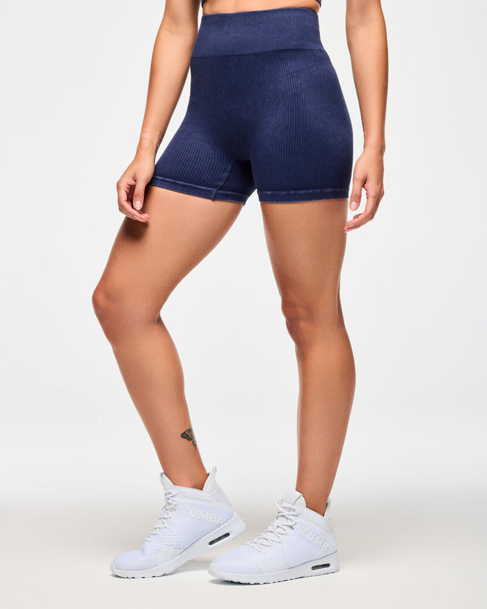 Side view of denim corduroy blue biker shorts with white "Zumba" text on the waistline.