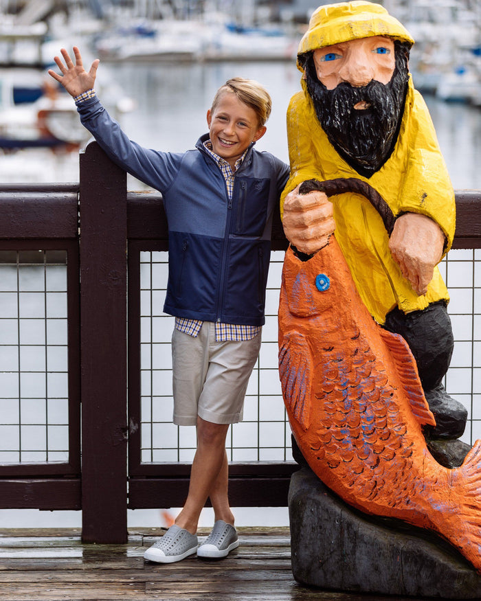 The lifestyle view of the Kid's Grey T3 Gulf Short by Southern Tide - Seagull Grey