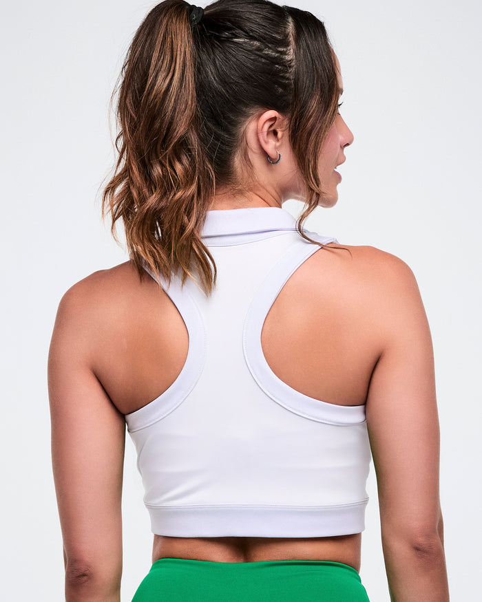 Back view of a female model wearing a white Zumba racerback polo.