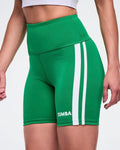 Female model wearing green Zumba shorts with white stripes down the side.