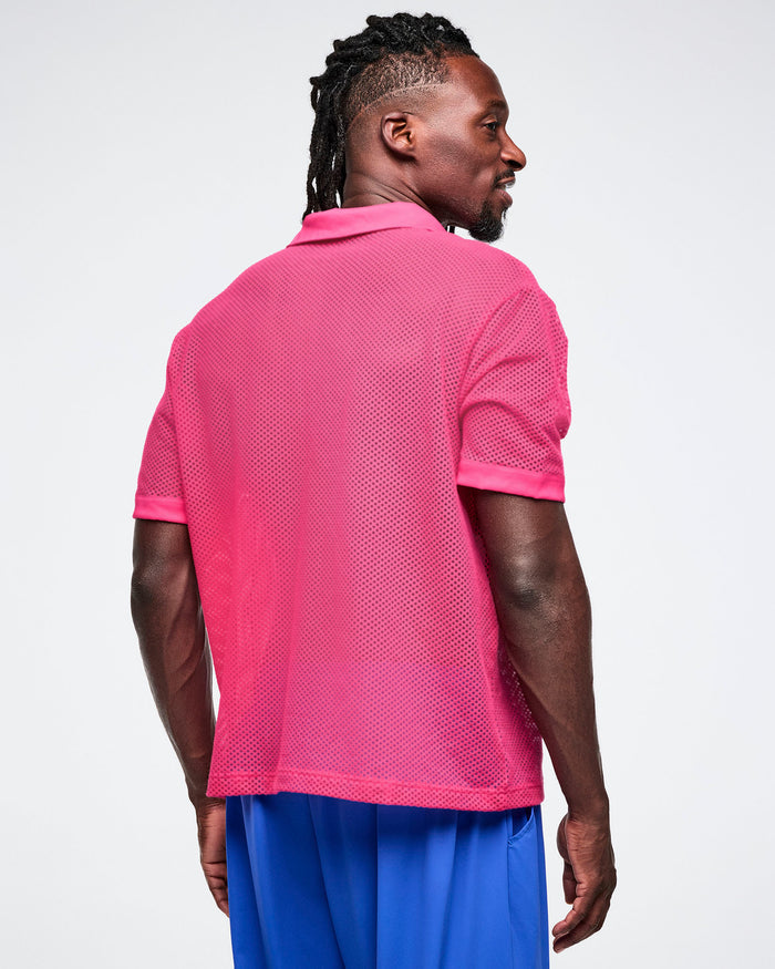Male model wearing a pink mesh polo shirt and blue shorts on a white background, viewed from the back.
