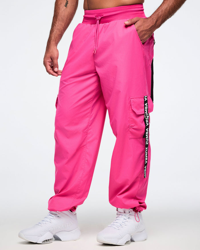 Male model wearing pink cargo pants with a brand logo on a white background.
