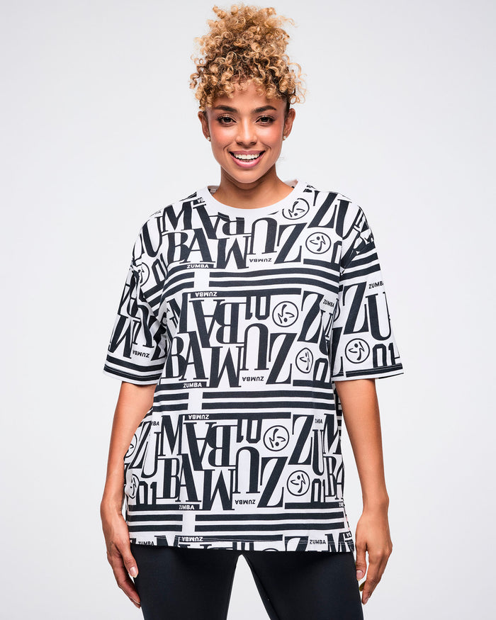 Female model wearing a black and white patterned Zumba boxy top.