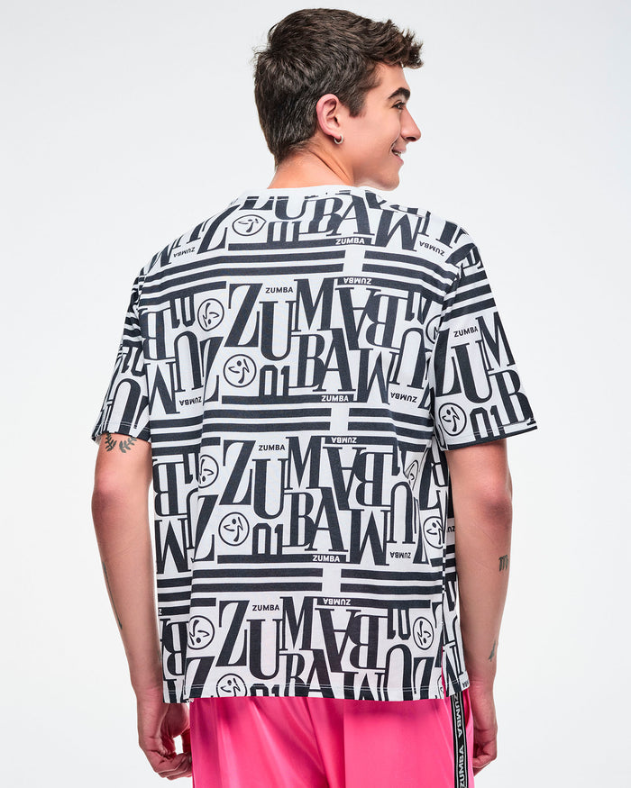 Back view of a male model wearing a black and white patterned Zumba boxy top paired with pink pants.