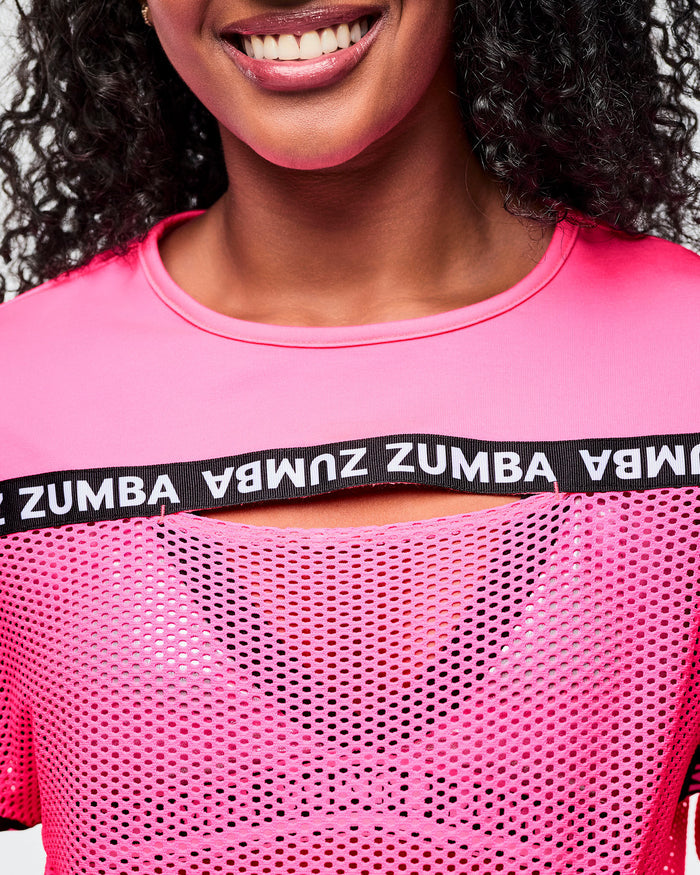 Close-up of the female model wearing a pink Zumba crop top.