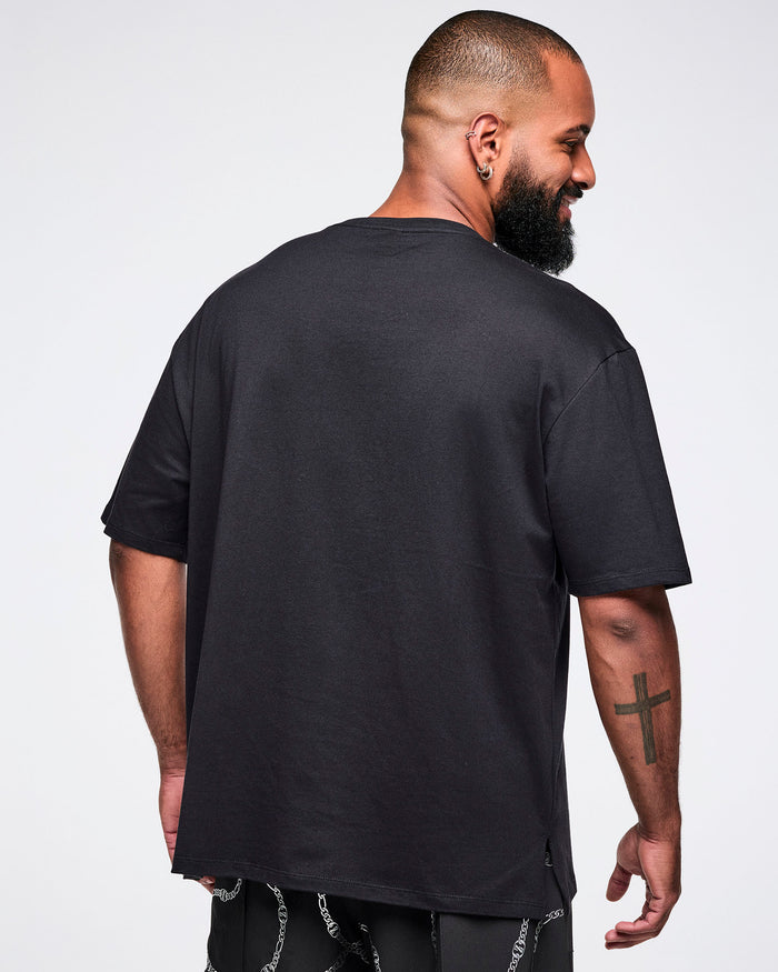 Back view of a male model wearing a black Zumba tee on a white background.