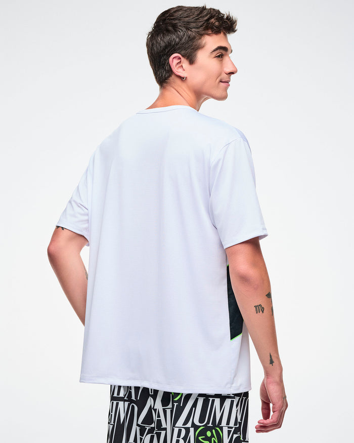 Back view of a male model wearing a white Zumba top on a plain background.