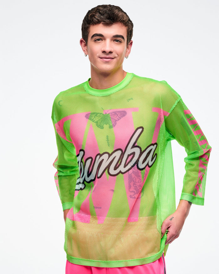 Male model wearing a neon green mesh long-sleeve Zumba top with bold pink graphics and white cursive “Zumba,” paired with pink pants.