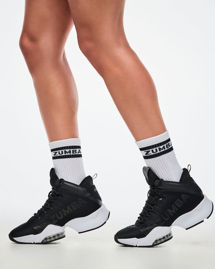 Close-up of female model in S/M white and black Zumba socks paired with white and black shoes.