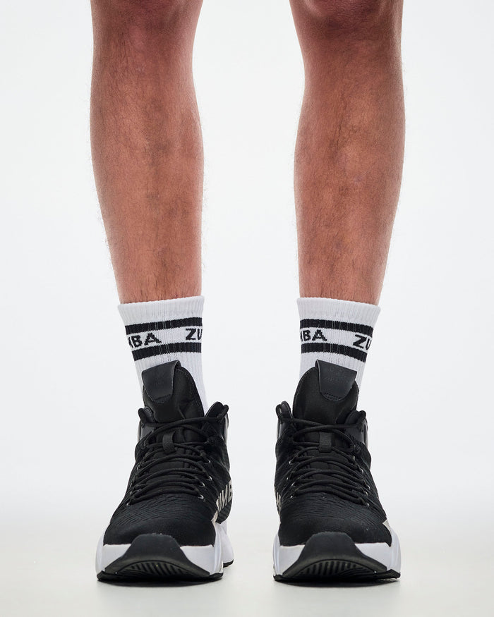Close-up of male model in L white and black Zumba socks paired with white and black shoes.