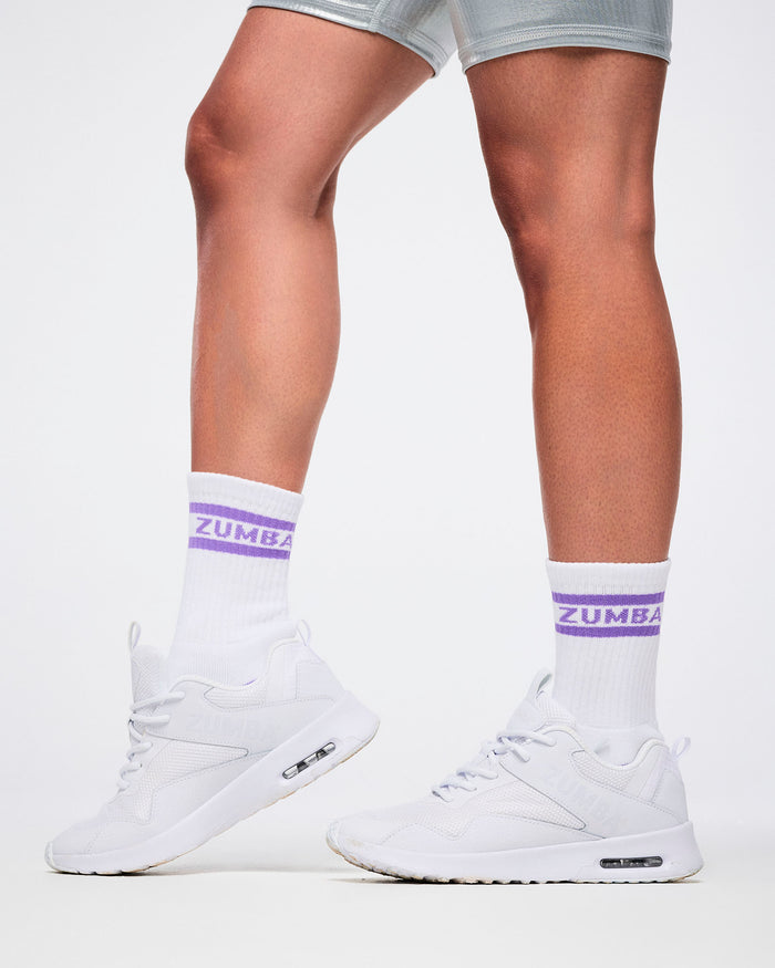 Close-up of female model in S/M white and purple Zumba socks paired with white shoes.