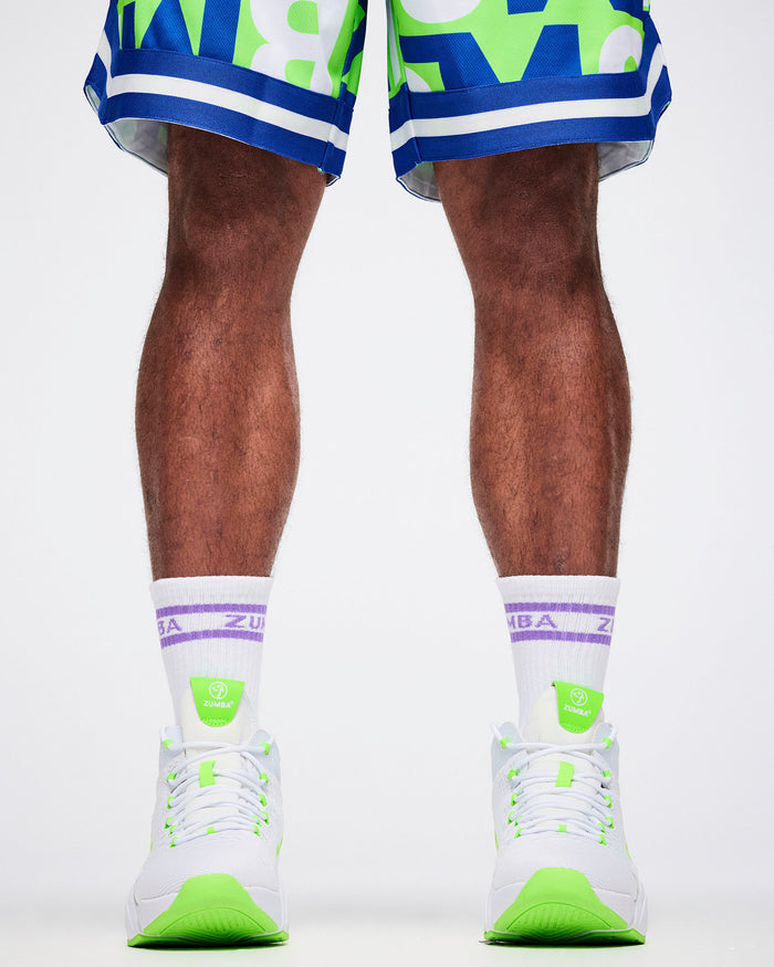 Close-up of male model in L white and purple Zumba socks paired with white and green shoes.