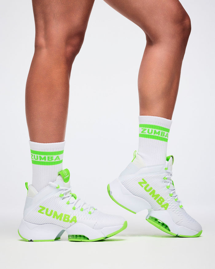 Close-up of female model in S/M white and green Zumba socks paired with white and green shoes.