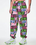 Male model wearing multicolored woven pants paired with white and green shoes.