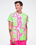 Male model wearing a bright neon green and pink patterned white tee paired with pink pants.