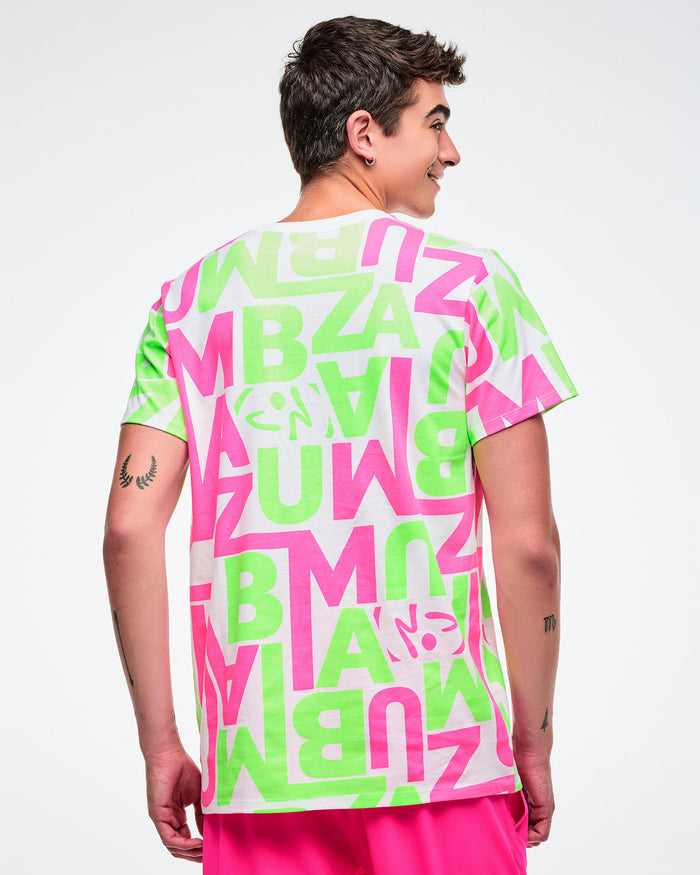 Back view of a male model wearing a bright neon green and pink patterned white tee paired with pink pants.
