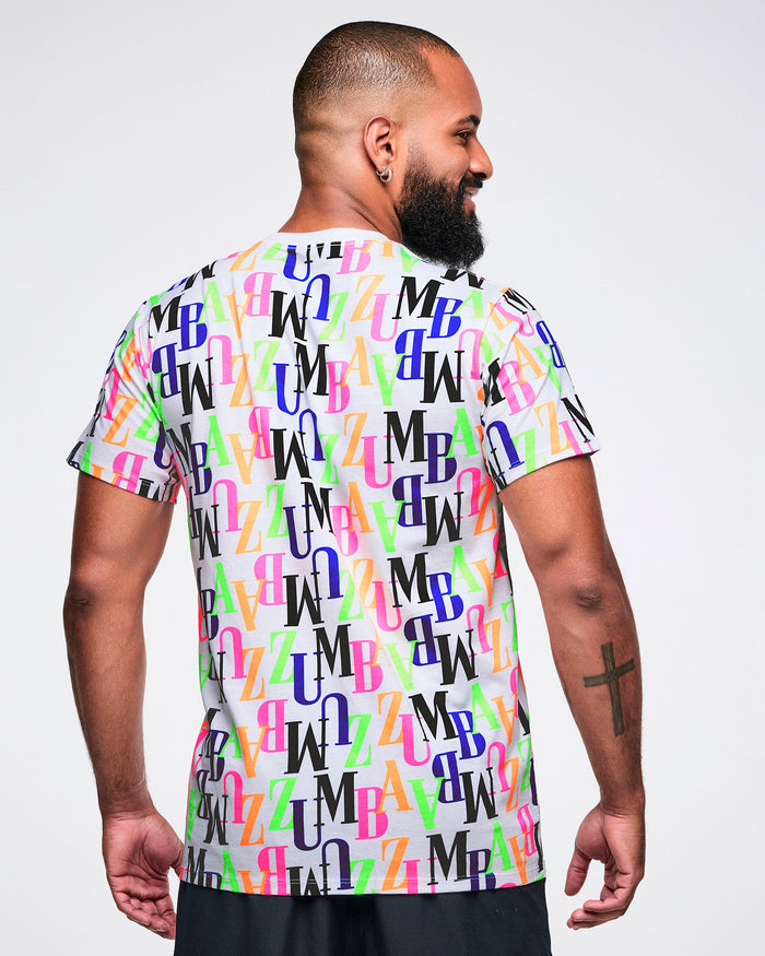 Back view of a male model wearing a colorful 'ZUMBA' patterned t-shirt and black shorts.