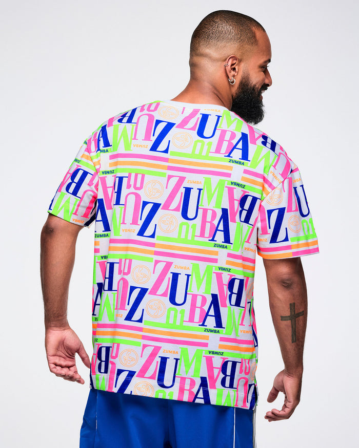 Back view of a male model wearing a colorful 'Zumba' t-shirt on a white background.
