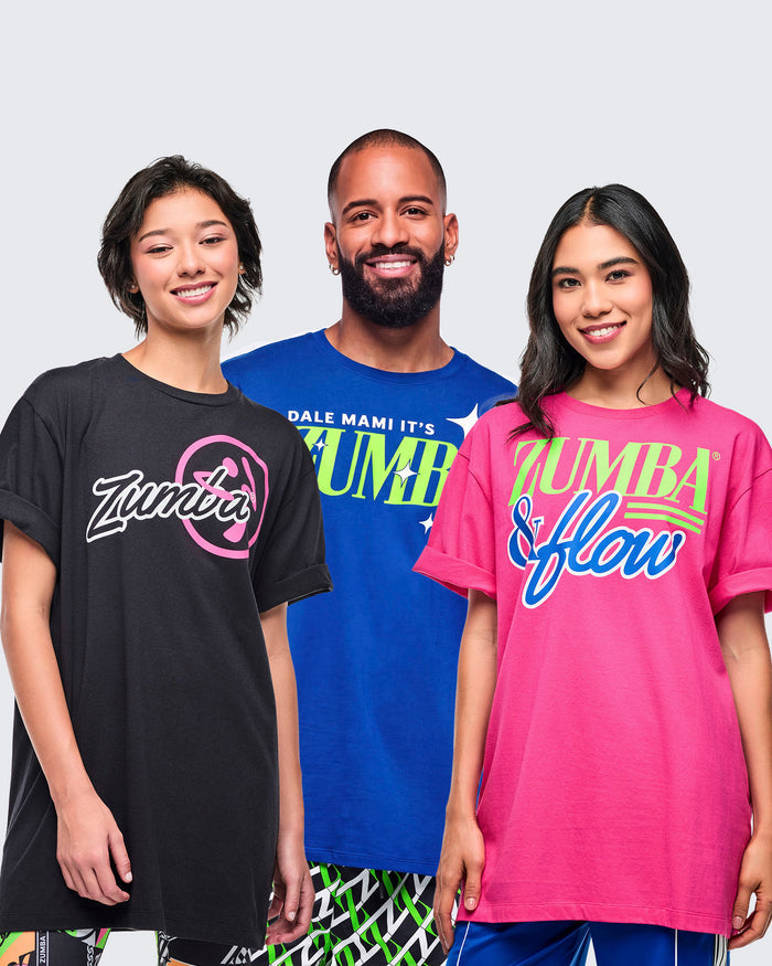 Three models wearing Zumba branded t-shirts in black, blue and pink on a plain background.