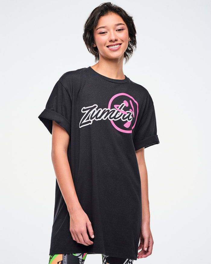 Female model wearing a black Zumba t-shirt on a white background.