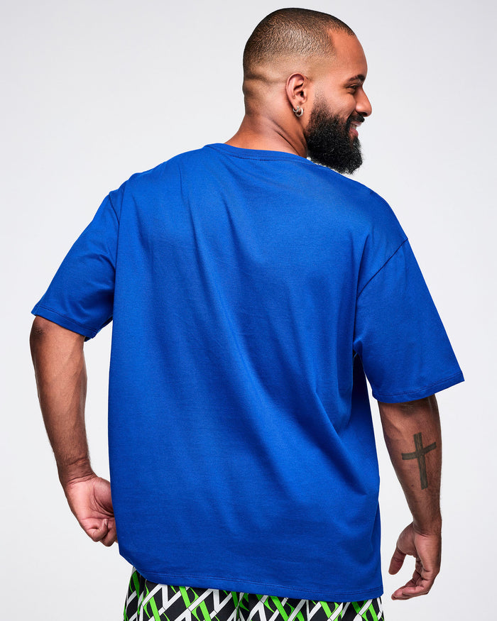 Back view of a male model wearing a blue Zumba t-shirt on a white background.
