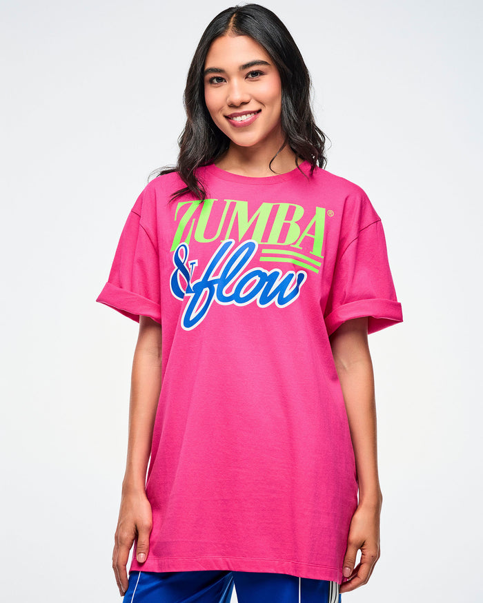 Female model wearing a pink Zumba shirt with colorful text on a white background.