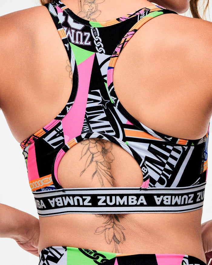 Back view of a a female model wearing a multicolored Zumba sports bra with racerback straps.