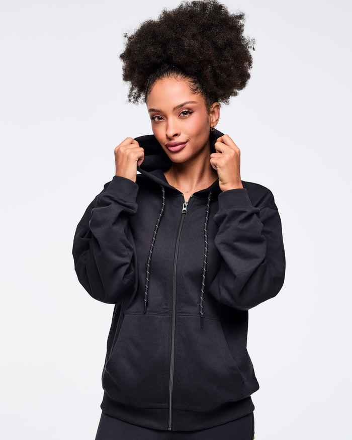 Female model wearing a black hoodie against a light gray background.