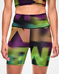 Close-up of pink, purple, orange, and aqua ombre biker shorts with a blurred, oversized "ZUMBA" wordmark print.