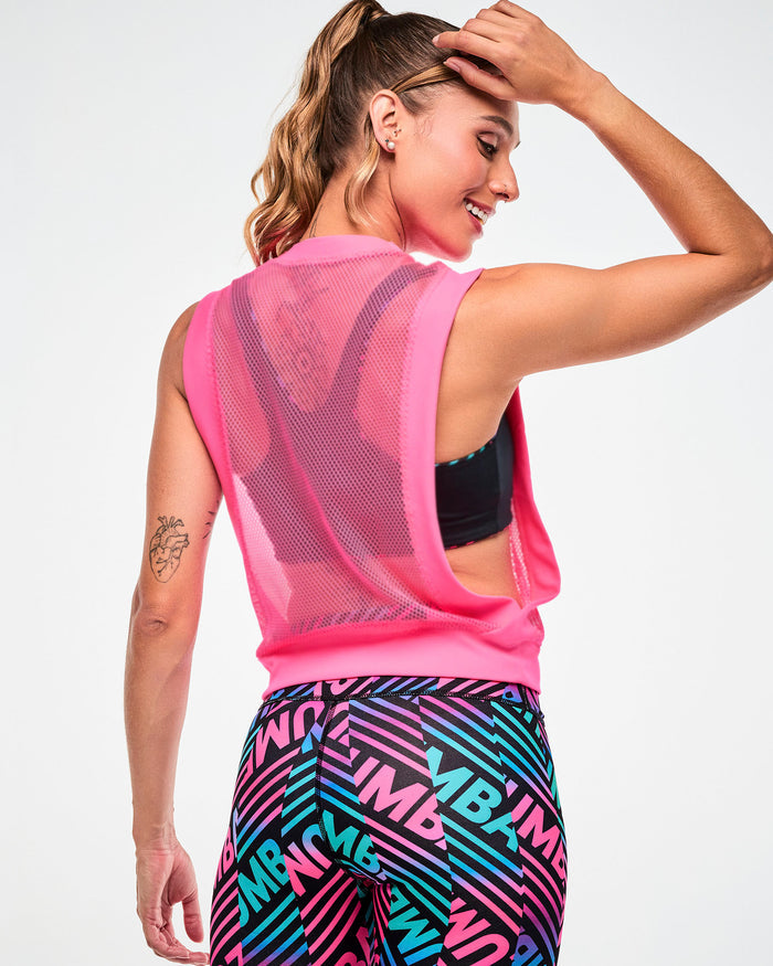 Shown from the back with a black sports bra visible, female model wearing a pink tank, paired with black, pink, and aqua striped leggings.