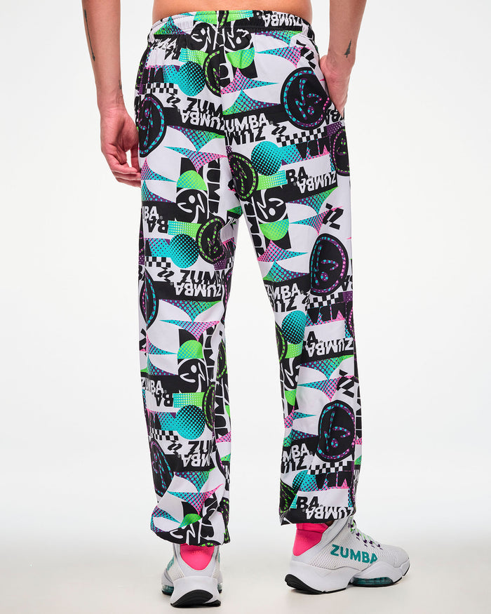 Back view of a male model wearing white track pants with an all-over abstract print, paired with white sneakers.