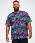 Male model wearing a black tee with a colorful pink, aqua, and purple diagonal striped "ZUMBA" broken-pattern print.