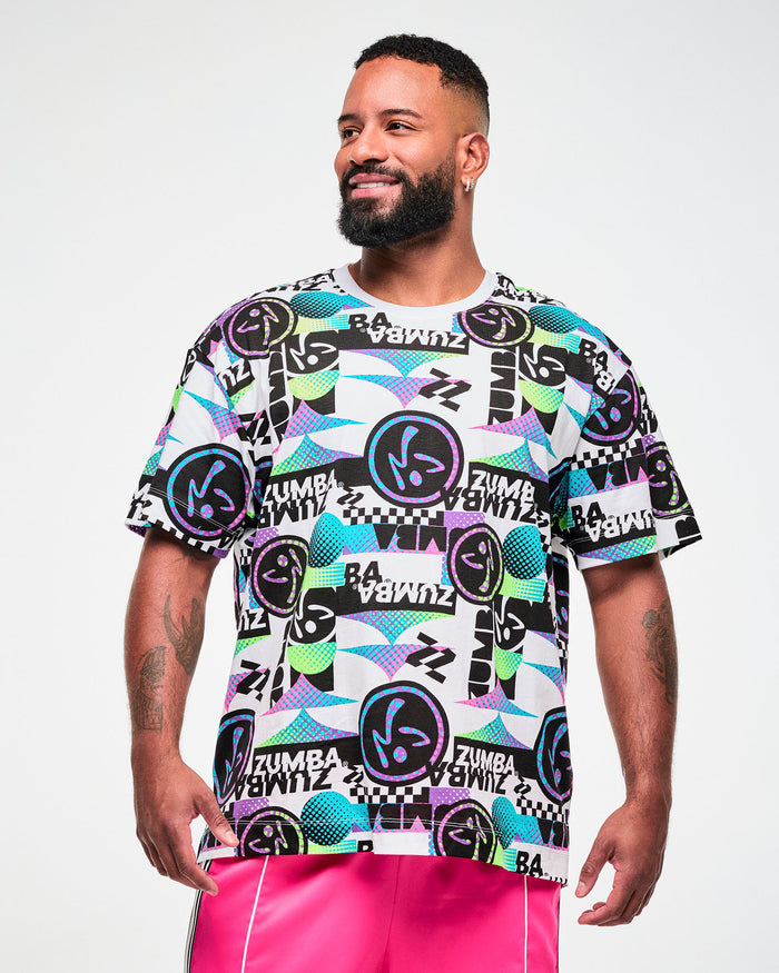 Male model wearing a white tee with a busy black, purple, and aqua graphic pattern of repeated "ZUMBA" text and Zumbito logos.