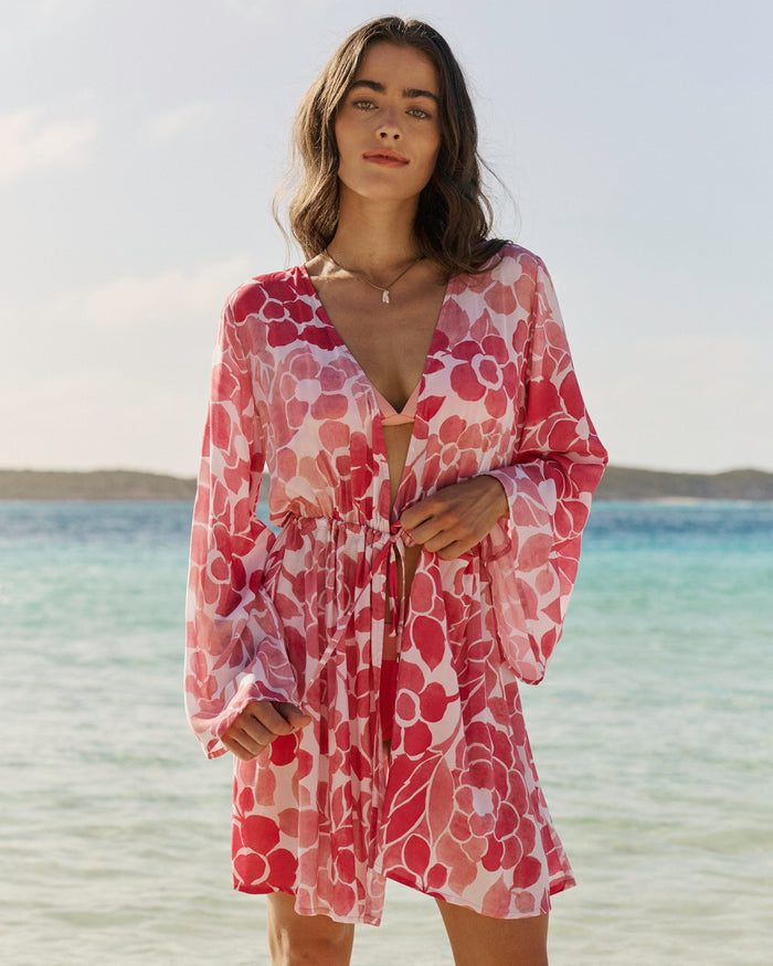 The front lifestyle view of the Southern Tide Floral Bell Sleeve Short Tunic Cover-Up by Southern Tide - Island Pink