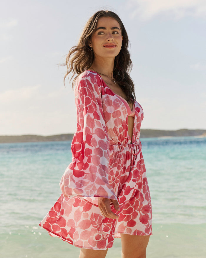 The front side lifestyle view of the Southern Tide Floral Bell Sleeve Short Tunic Cover-Up by Southern Tide - Island Pink