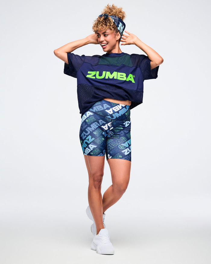 Female model wearing Zumba branded outfit and a blue bandana as a hair tie.