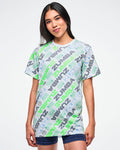 Female model wearing a Zumba tee with a blue and green 'ZUMBA' logo pattern on a white background.