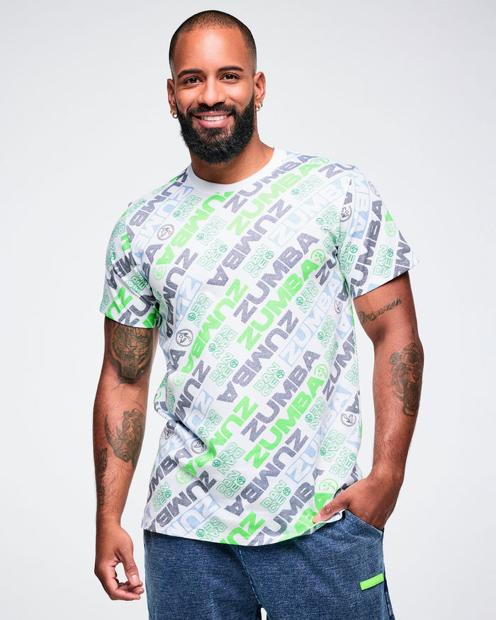 Male model wearing a Zumba tee with a blue and green 'ZUMBA' logo pattern on a white background.