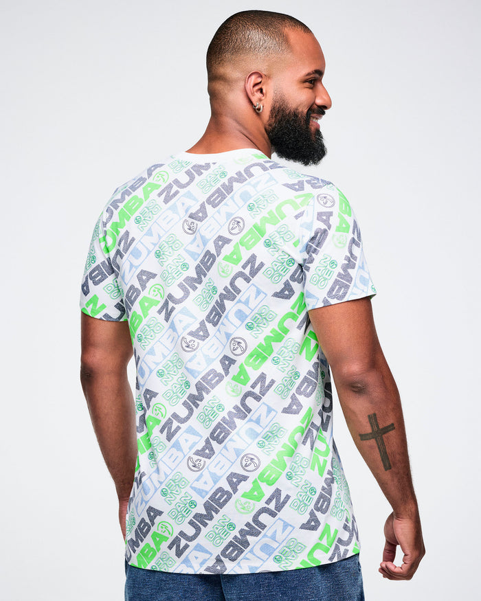 Back view of a male model wearing a Zumba tee with a blue and green 'ZUMBA' logo pattern on a white background.