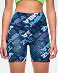Close-up of a female model wearing navy biker shorts with a blue and green “ZUMBA” logo pattern.