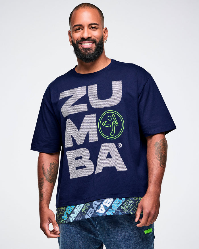 Close-up of male model wearing a blue 'Zumba' t-shirt with text and graphics on a light background.