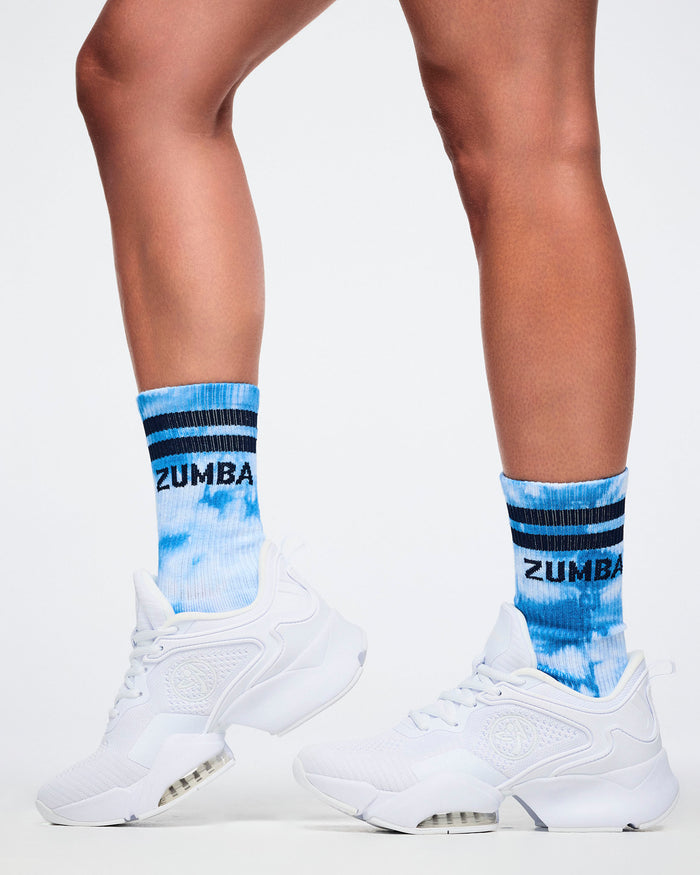 Female model wearing blue and white Zumba socks with white sneakers.