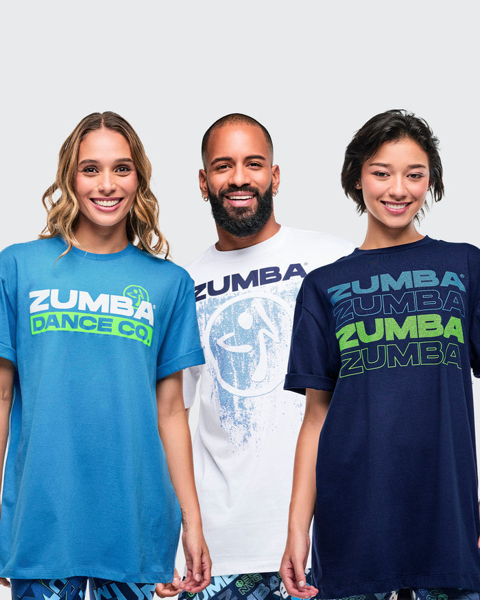 Three models wearing light blue, white, and dark blue Zumba T-shirts from a 12-pack.