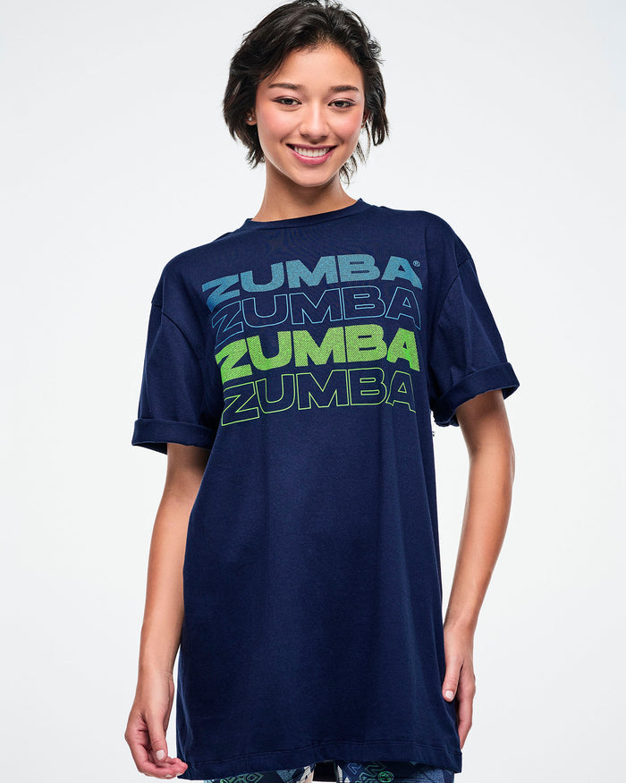 Female model wearing a dark blue Zumba t-shirt on a white background.
