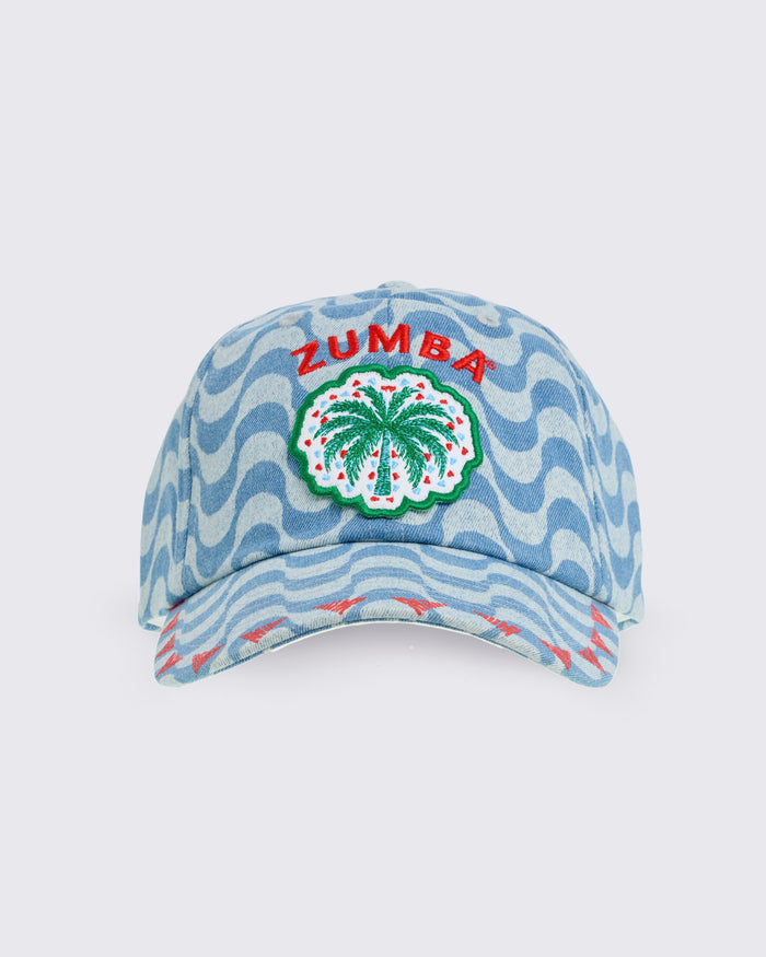 Light blue wavy-print baseball cap with embroidered “ZUMBA” text and palm-tree patch on the front panel, shown from the front on a white background.