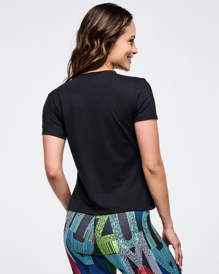 Back view of a fitted black short-sleeve tee and high-waisted, multicolor letter-print leggings on a female model, shown against a white background.